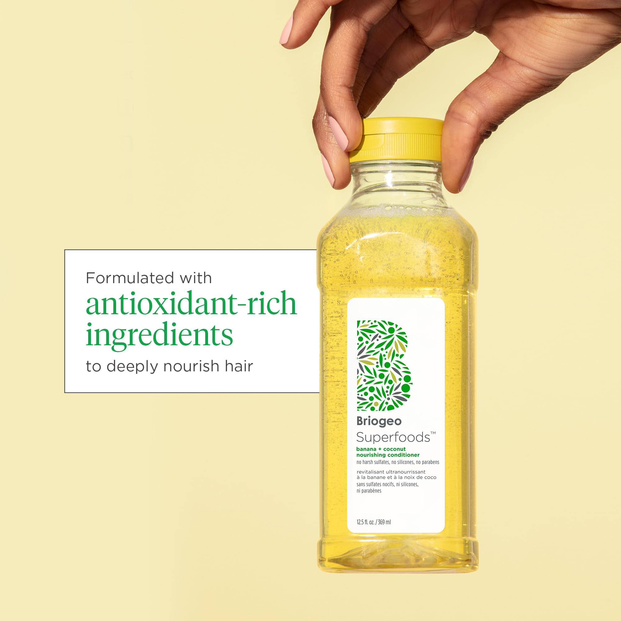 Close-up of Briogeo shampoo bottle highlighting banana extract's strengthening properties.