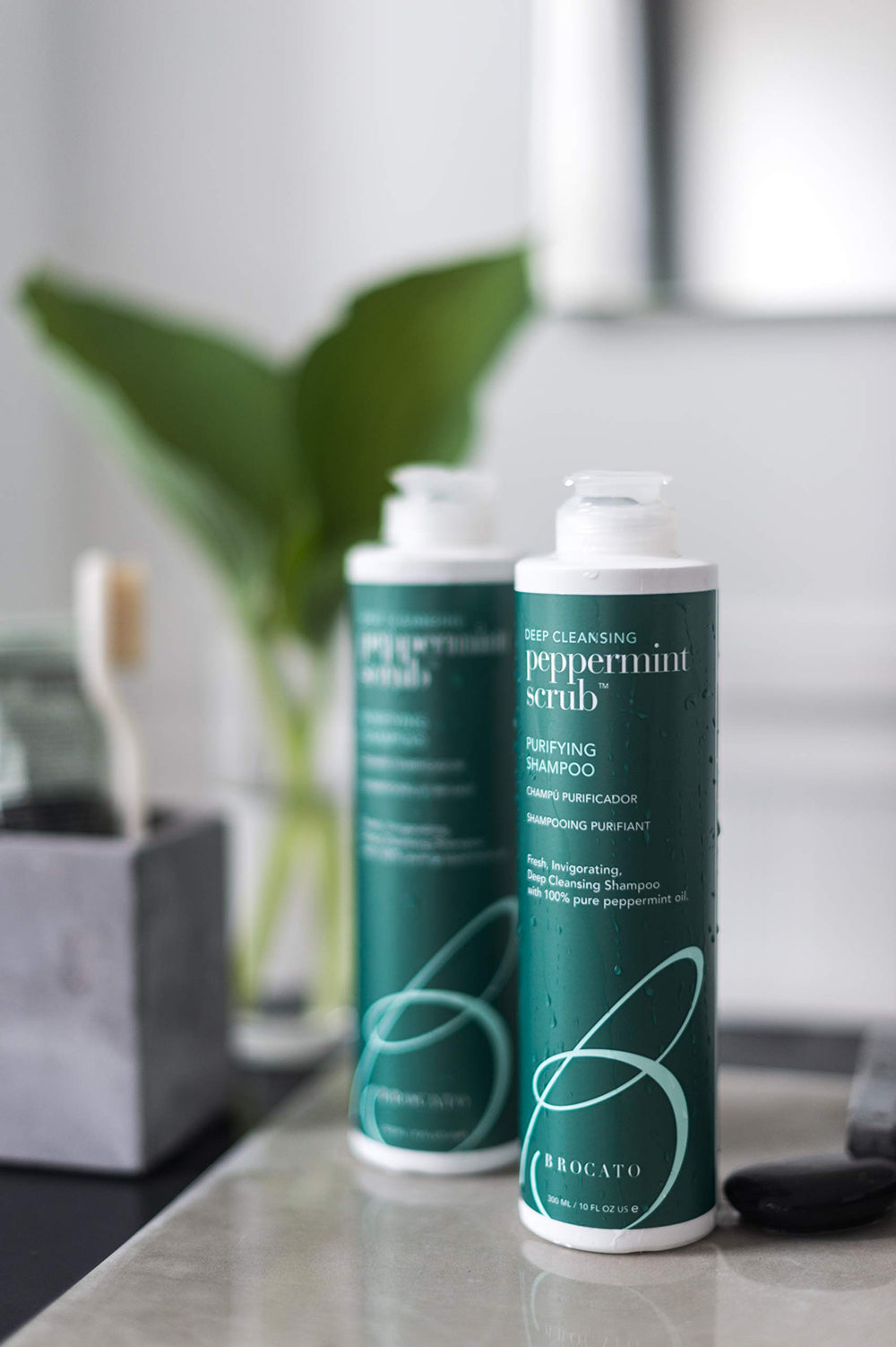 Brocato Peppermint Scrub Purifying Shampoo in-shower image highlights easy rinsing after a cooling wash.