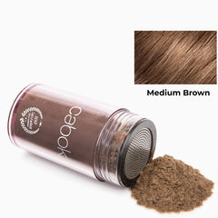 Caboki powder being shaken on thinning crown for instant density.