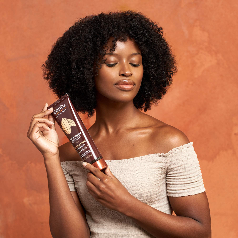 Cantu Therapy Cocoa Butter Body Cream applied by hands demonstrates quick, comfortable moisture