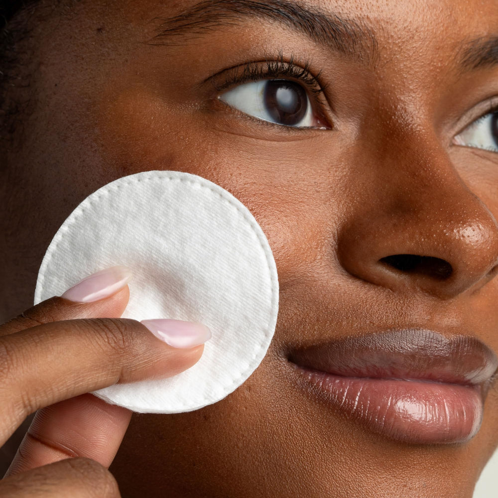 Cliganic Cotton Rounds on face demonstrates gentle makeup removal without lint.