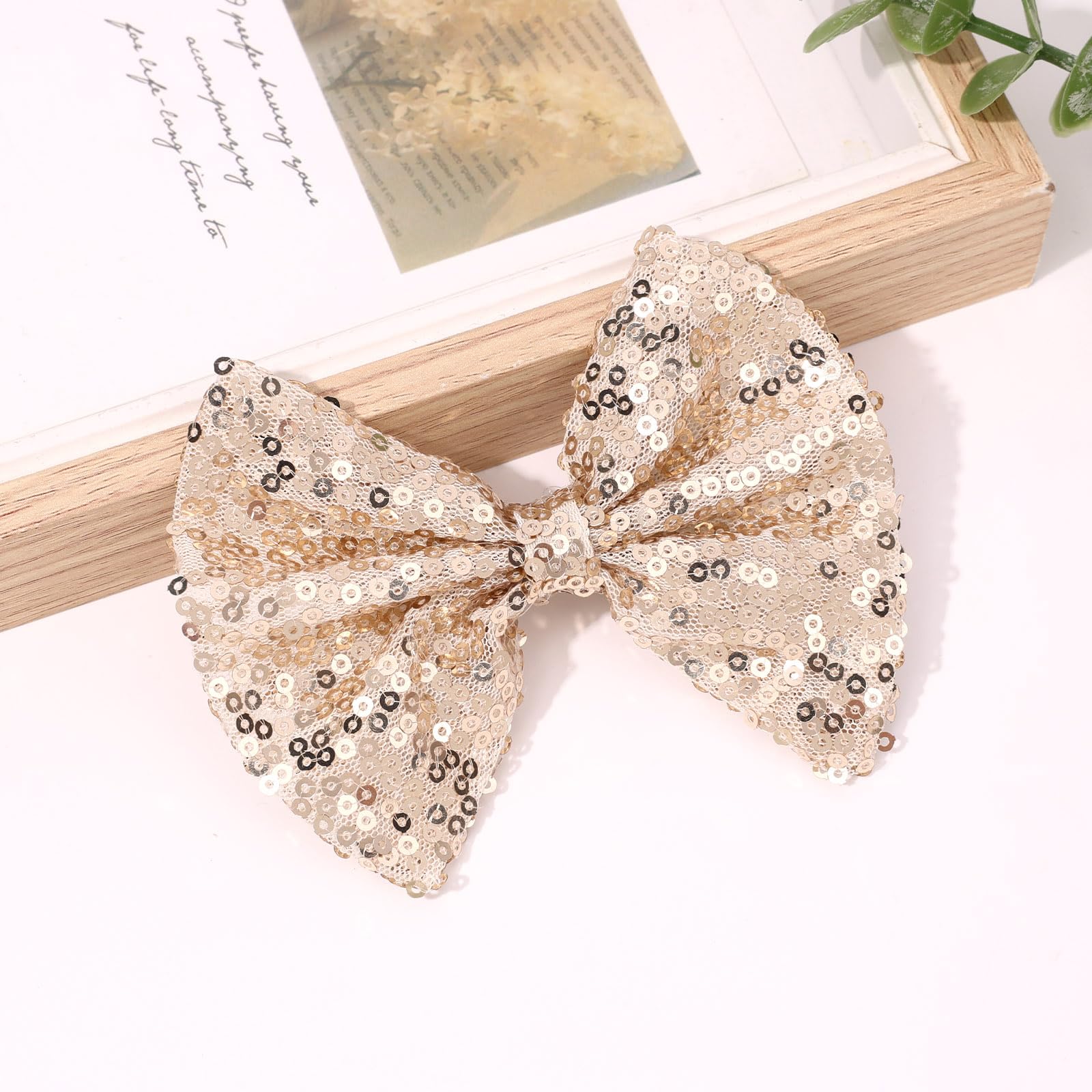 CN 2 inch clip detail on gold glitter bow for secure wear.