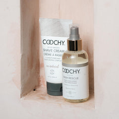 Coochy Rash Rescue bottle with botanical blend label standing beside towels promoting pore-tightening and irritation prevention.