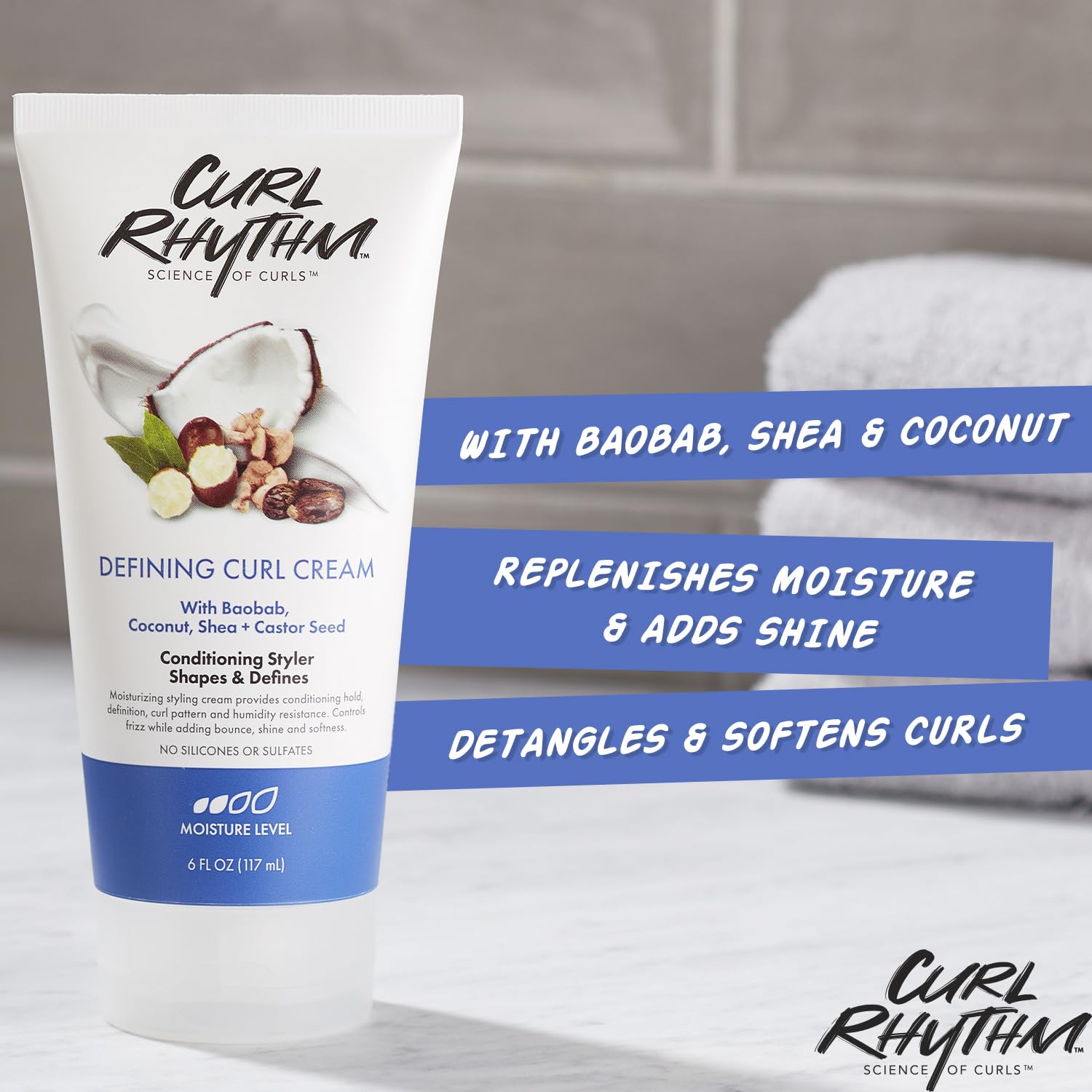 Curl Rhythm Defining Curl Cream bottle in hand demonstrates humidity resistance.