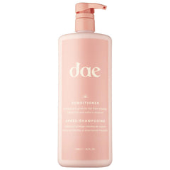 DAE Signature Conditioner bottle pouring for smooth hydration and frizz control.