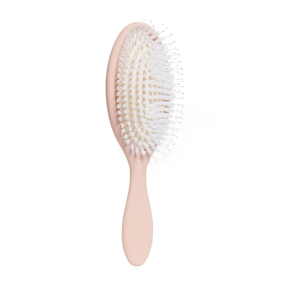 DAE Vegan Detangle Style Brush in hand shows gentle detangling for all hair types.