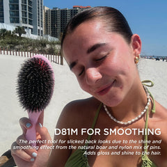 Denman D81M pink crush in hands with ergonomic grip for daily styling.
