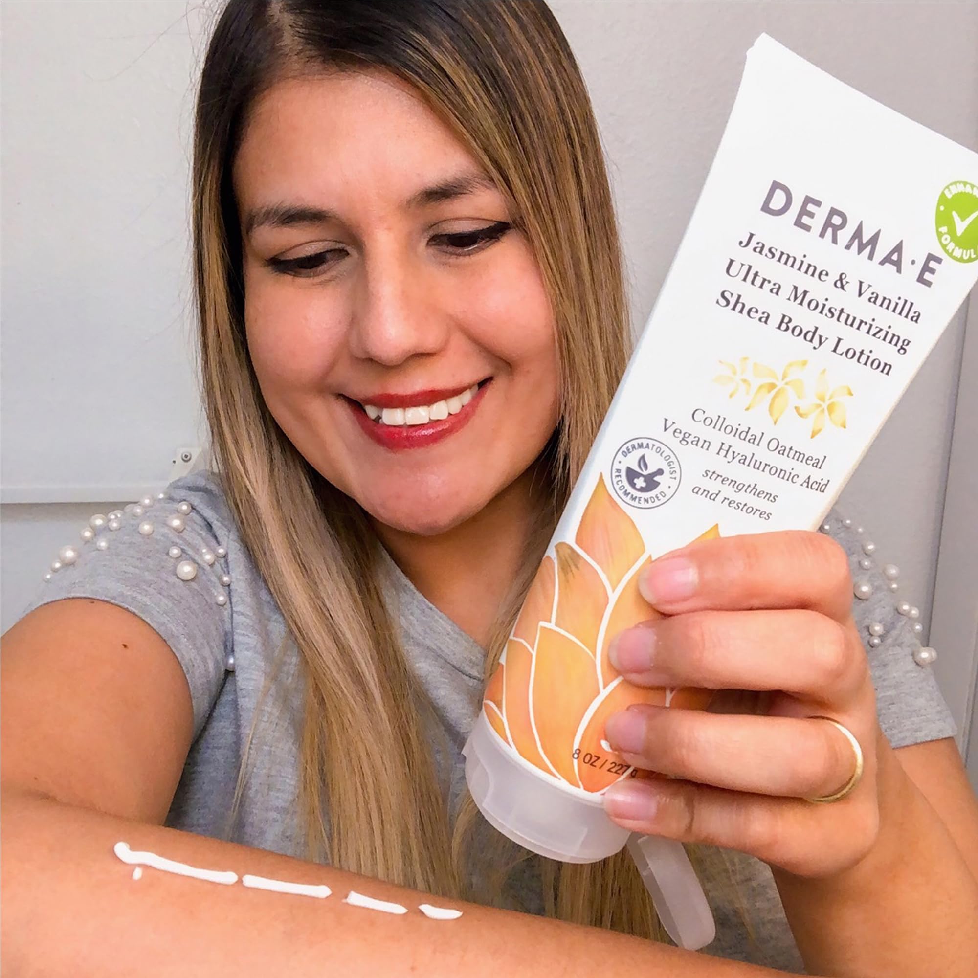Derma E applying lotion to elbows to relieve dryness.