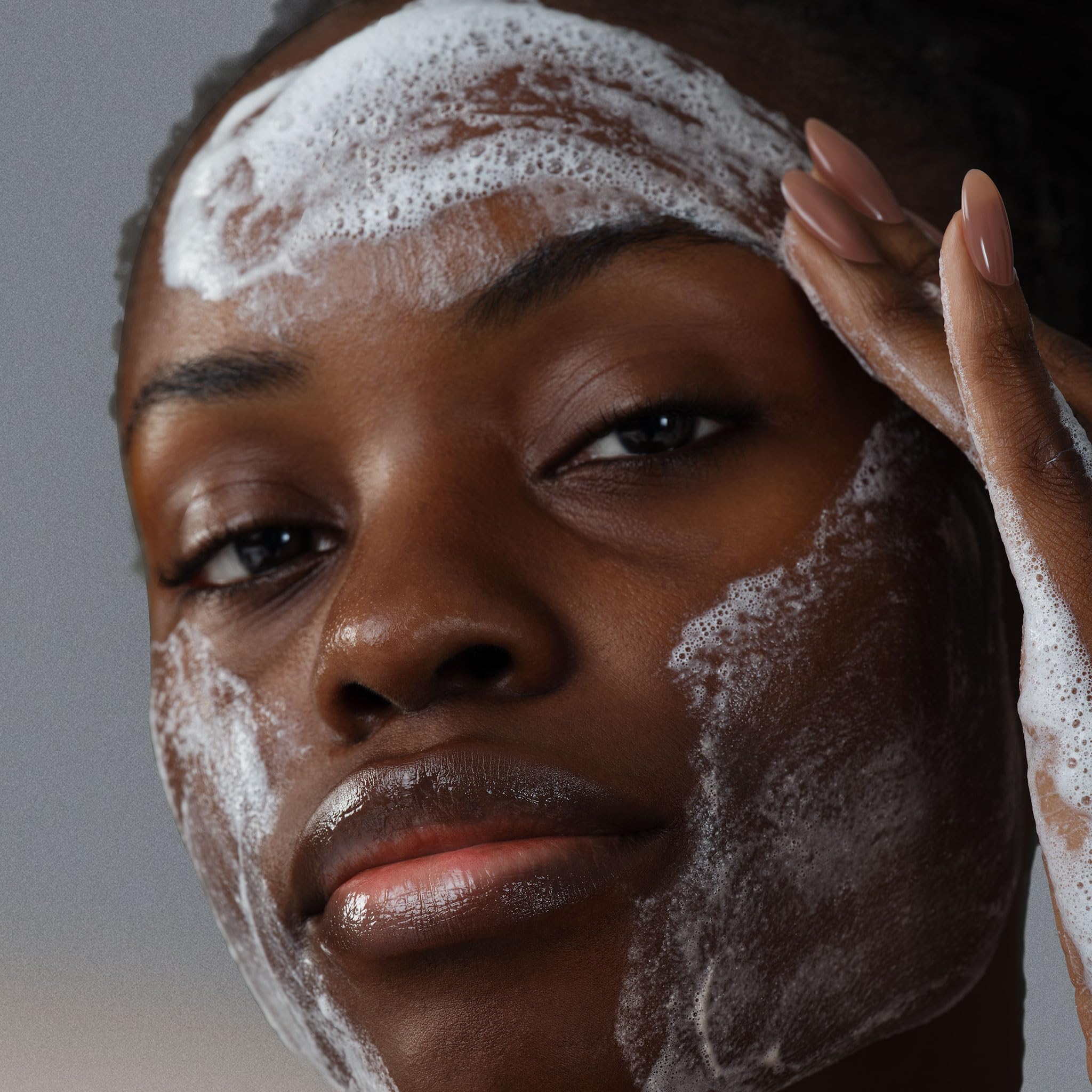 Dermalogica AGE Bright Clearing Serum being dabbed on cheek for brightening