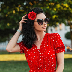 Dizila red rose hair clip on an updo creates a standout wedding accessory