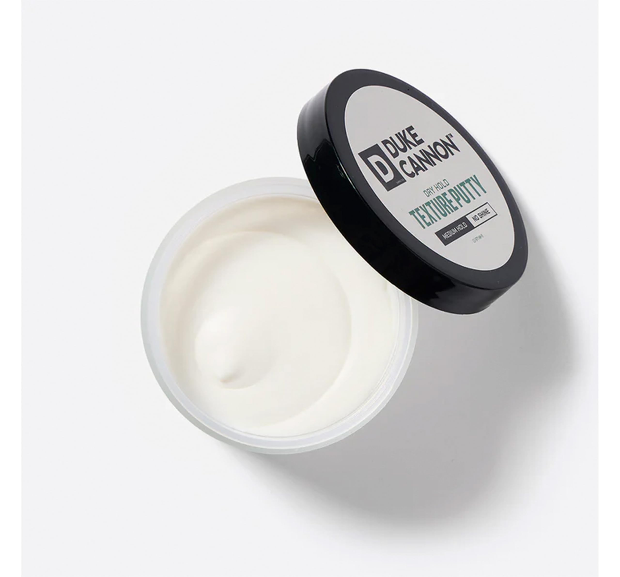 Duke Cannon Dry Hold Putty being applied to dry hair for matte texture.