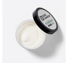 Duke Cannon Dry Hold Putty being applied to dry hair for matte texture.