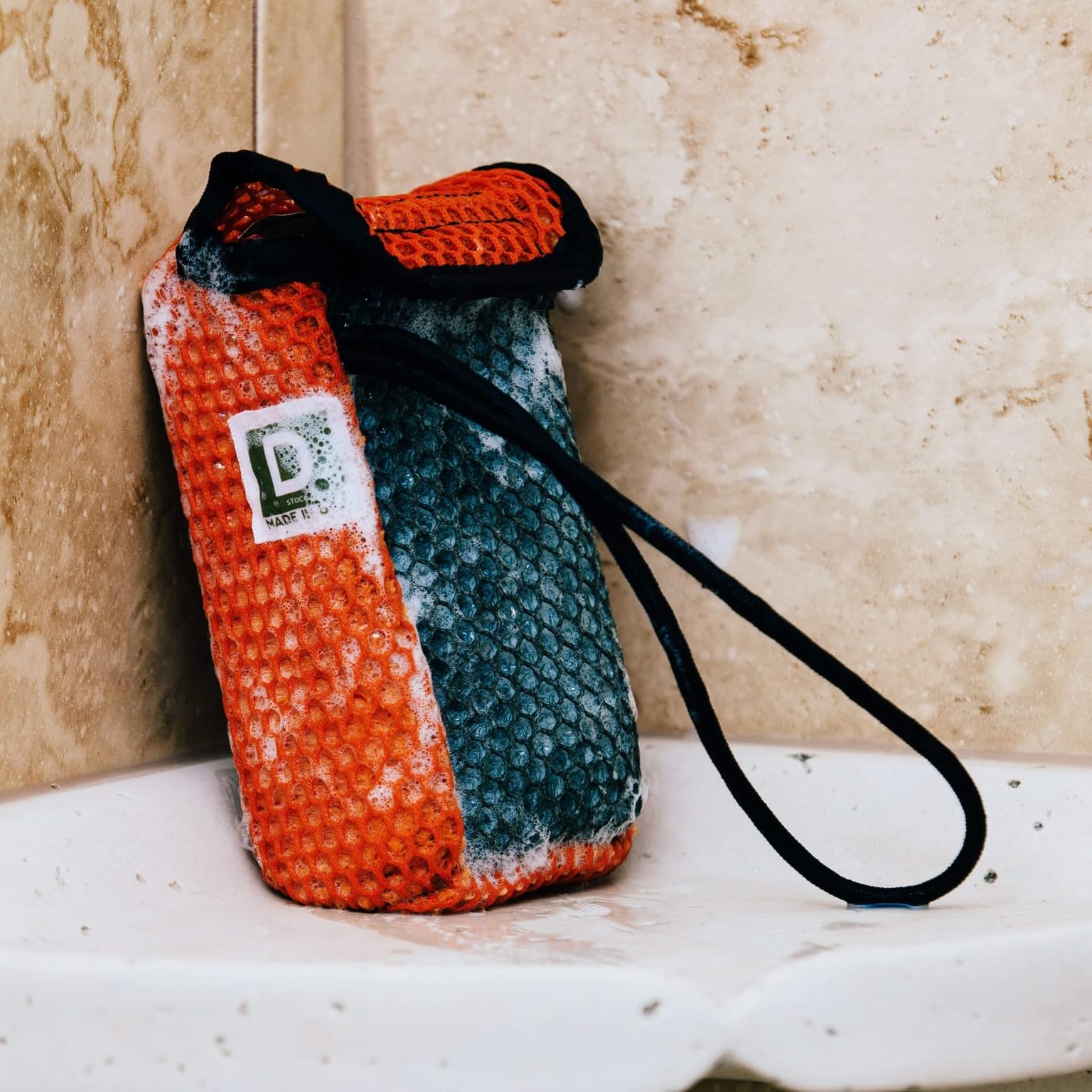 Duke Cannon Tactical Scrubber coarse mesh cleans tough grime on hands and feet.