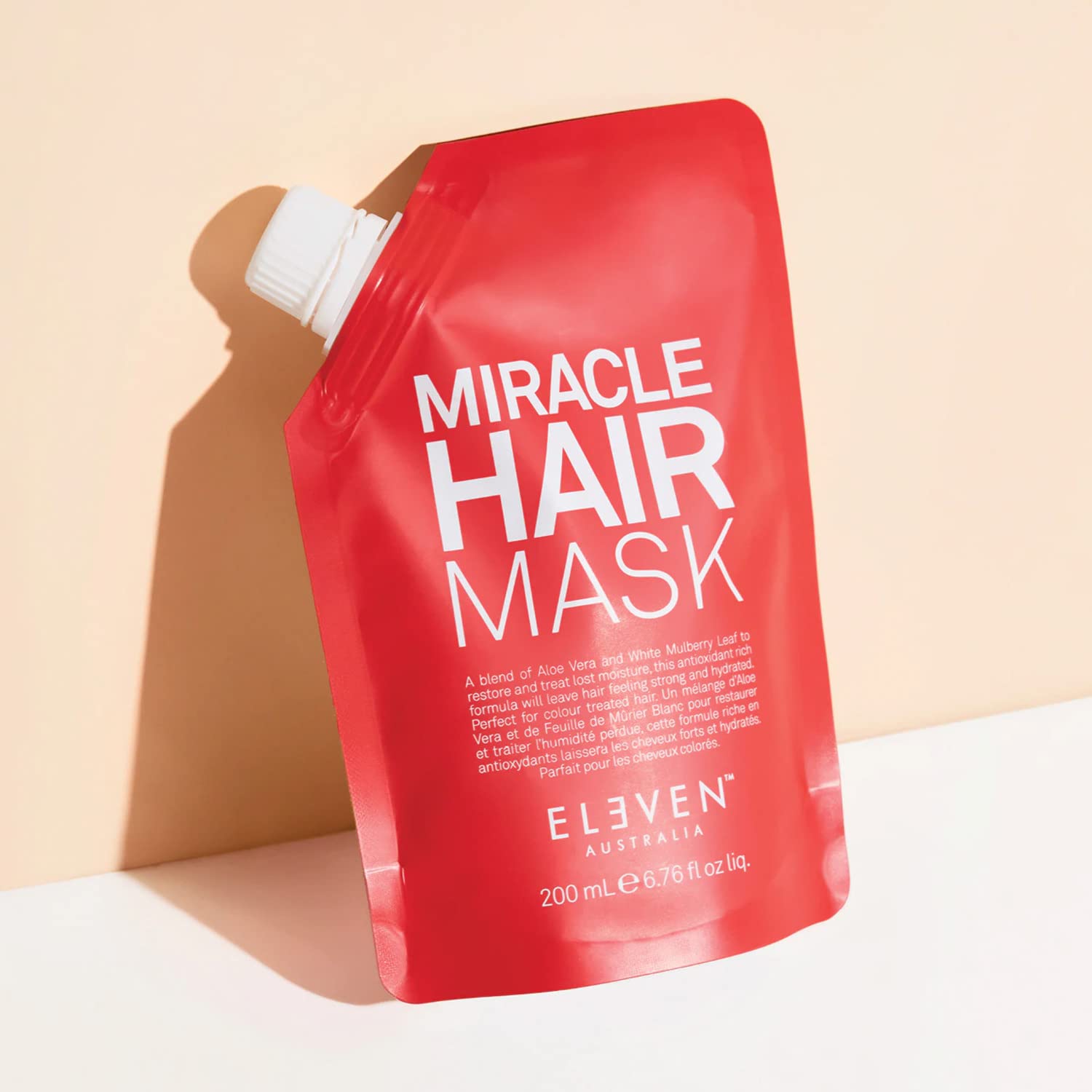 ELEVEN AUSTRALIA Miracle Hair Mask scooping formula indicating nourishing and smoothing results.