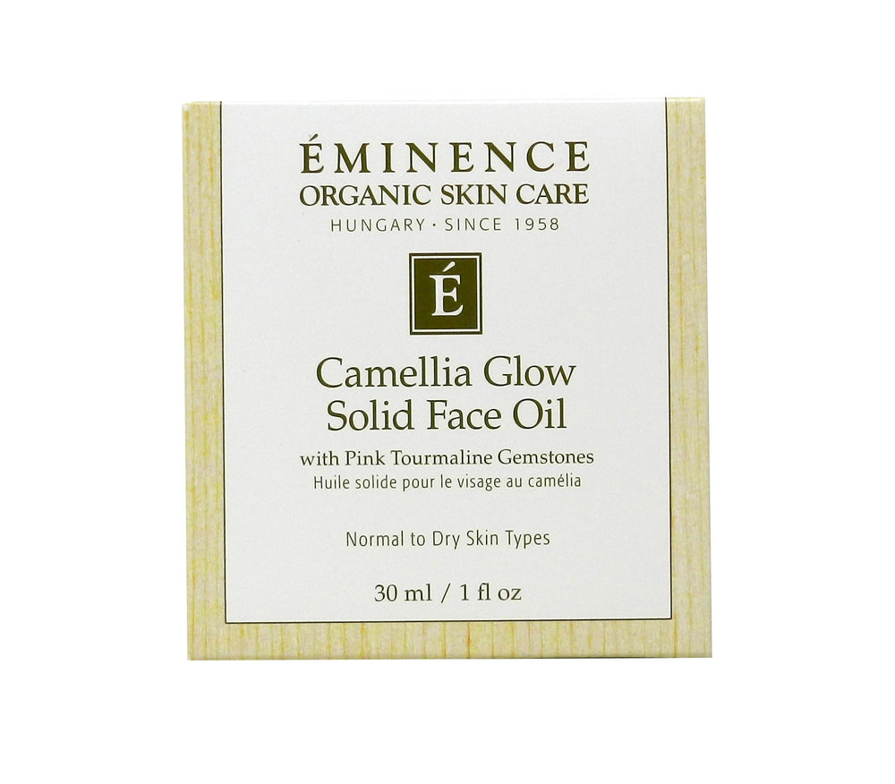 Eminence Camellia Glow solid face oil melting in palm for quick hydration.