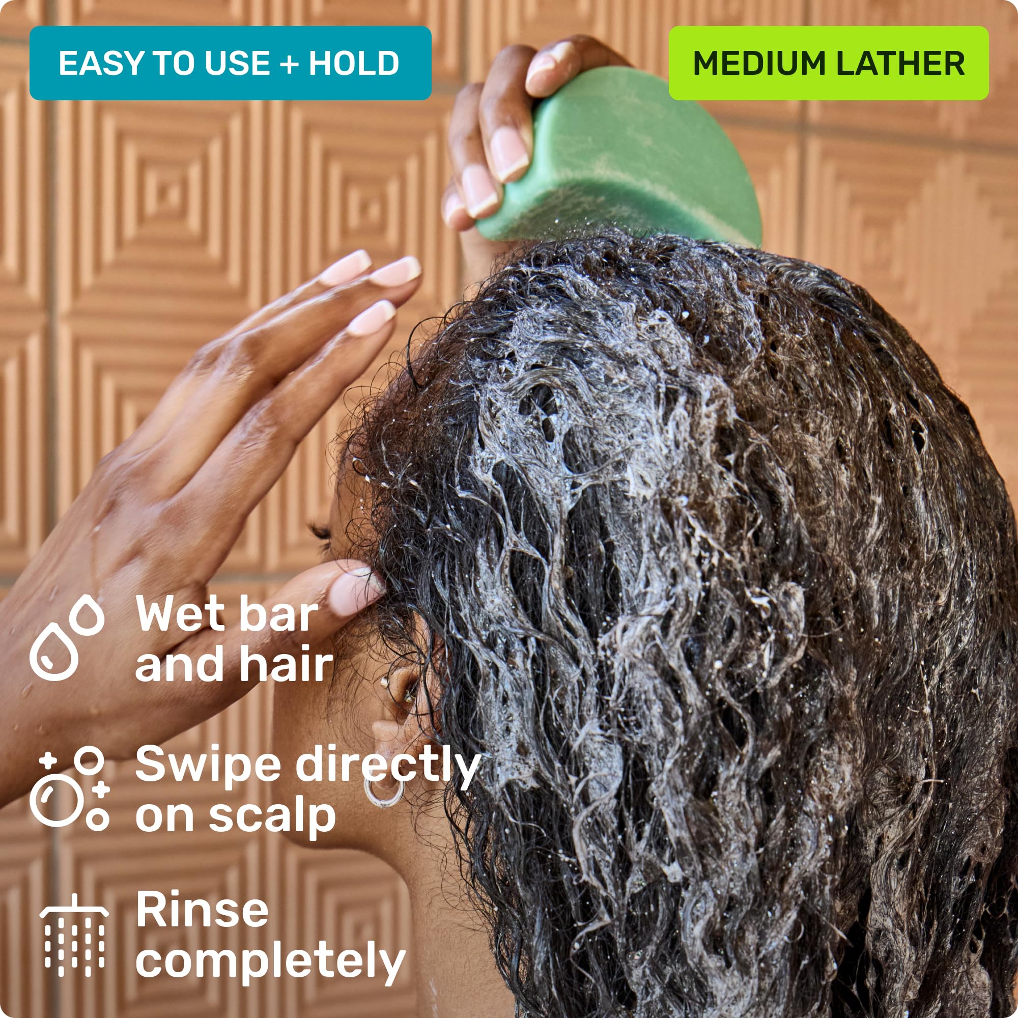 Ethique Professor Curl shampoo bar in use with lather on curly hair.