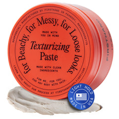 Firsthand texturizing paste bottle closeup for natural waves and volume