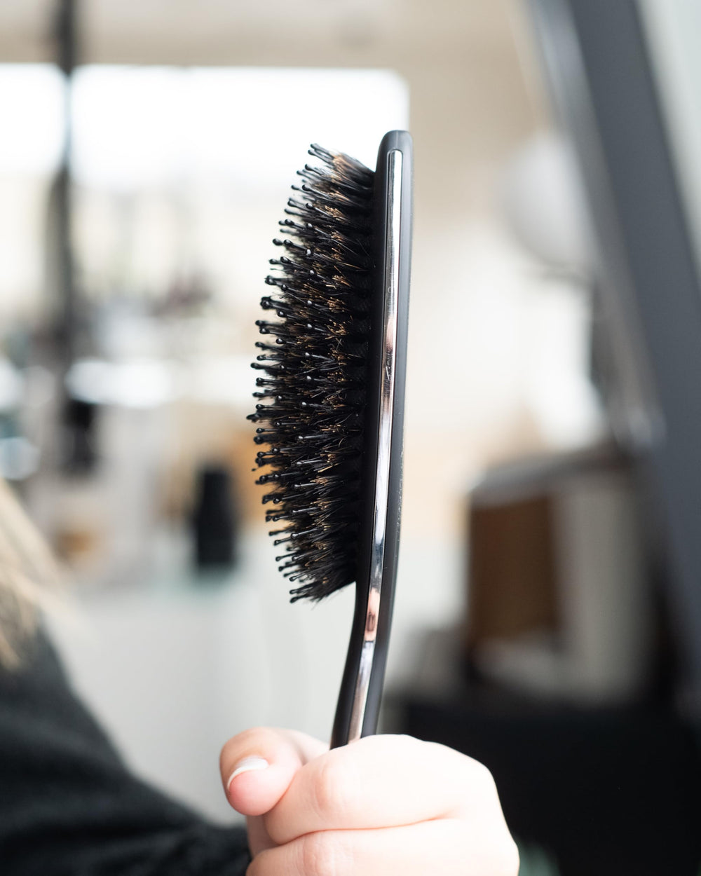 FRAMAR brush with black handle closeup emphasizing stylish, portable design.