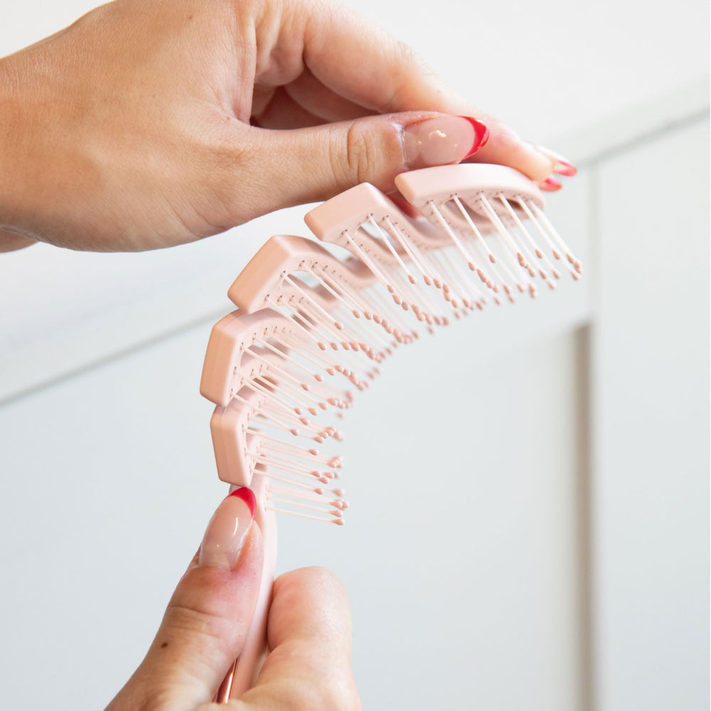 FRAMAR vented pink hair brush in hand for versatile styling and on-the-go use