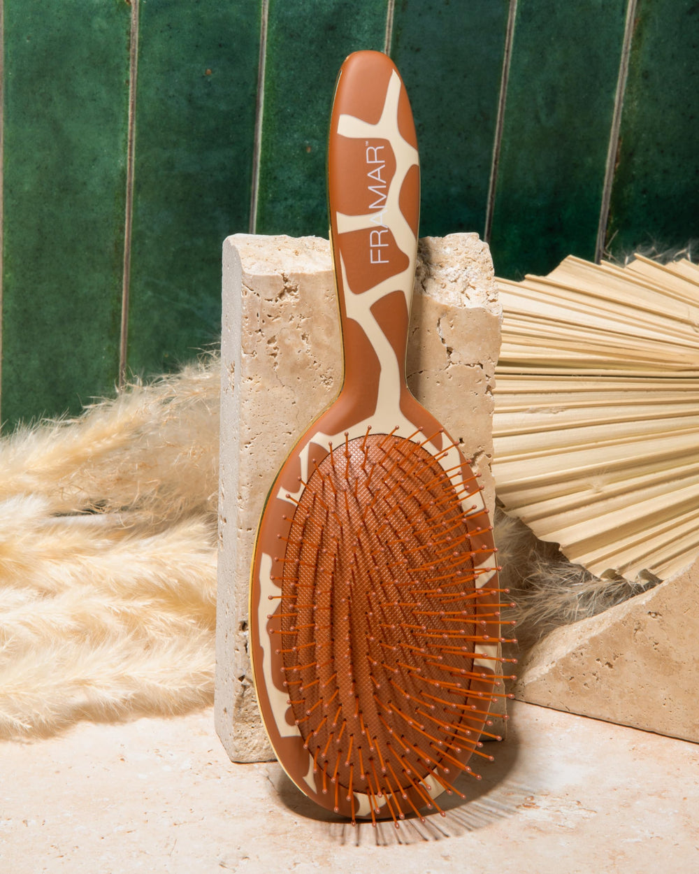 FRAMAR giraffe-pattern brush shown massaging scalp for healthy circulation.