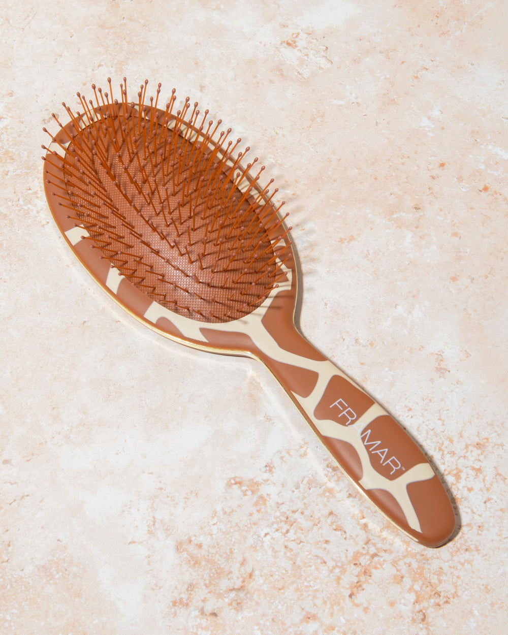FRAMAR compact detangler fits purse or bag for quick brushing.