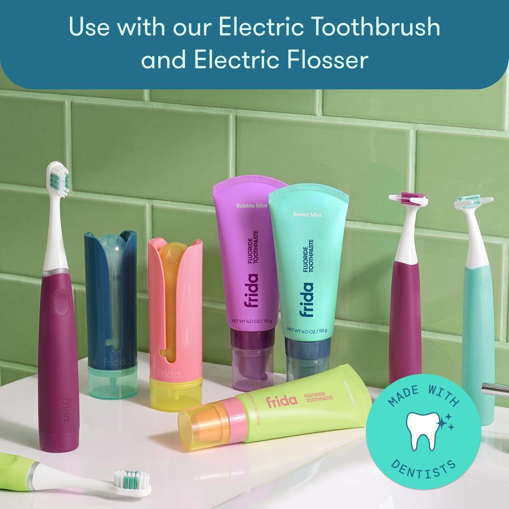 Frida tube next to toothbrush showing 4 oz size for travel convenience