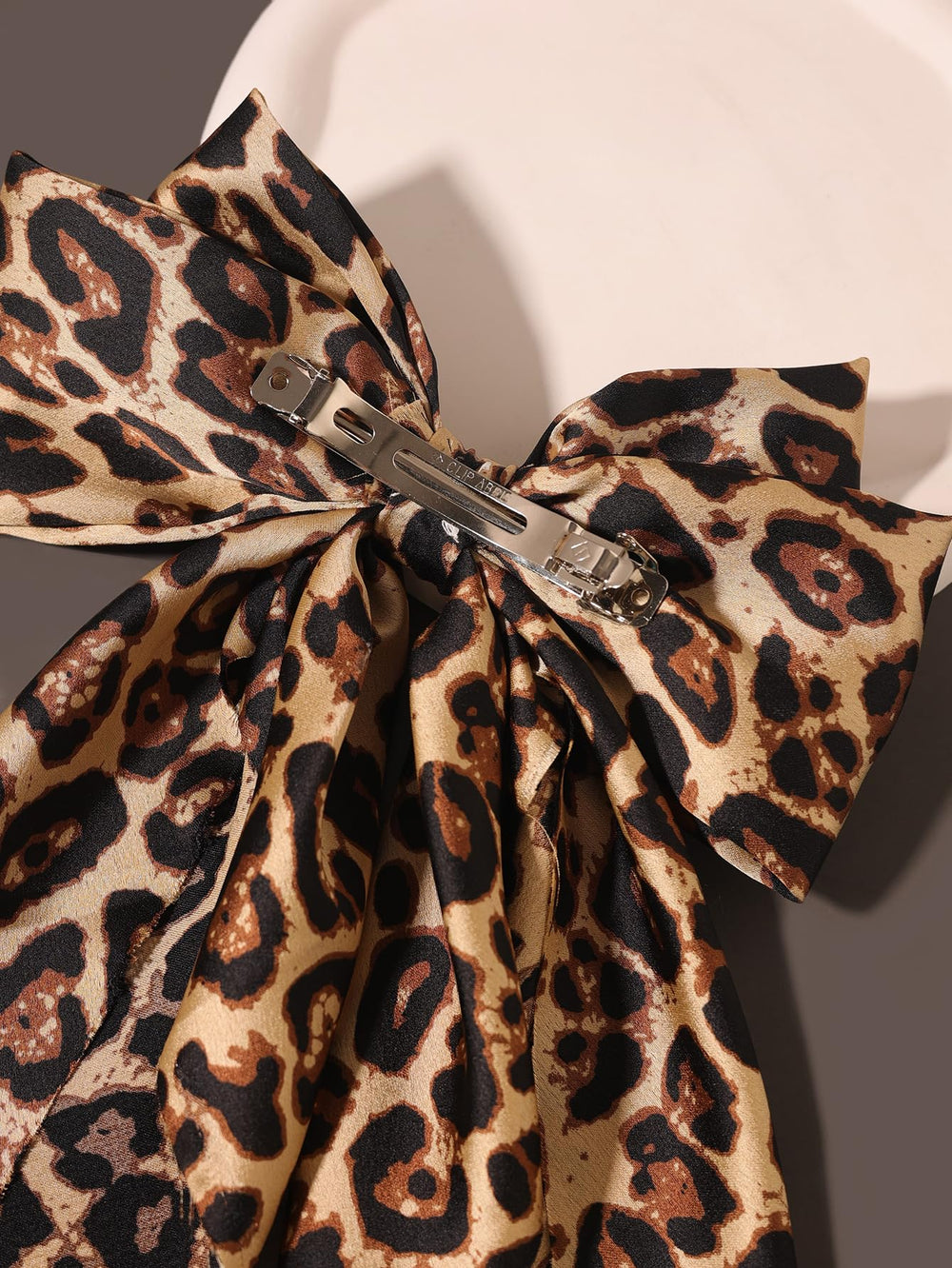 Furling Pompoms big bow hair clip camel worn for special occasions.