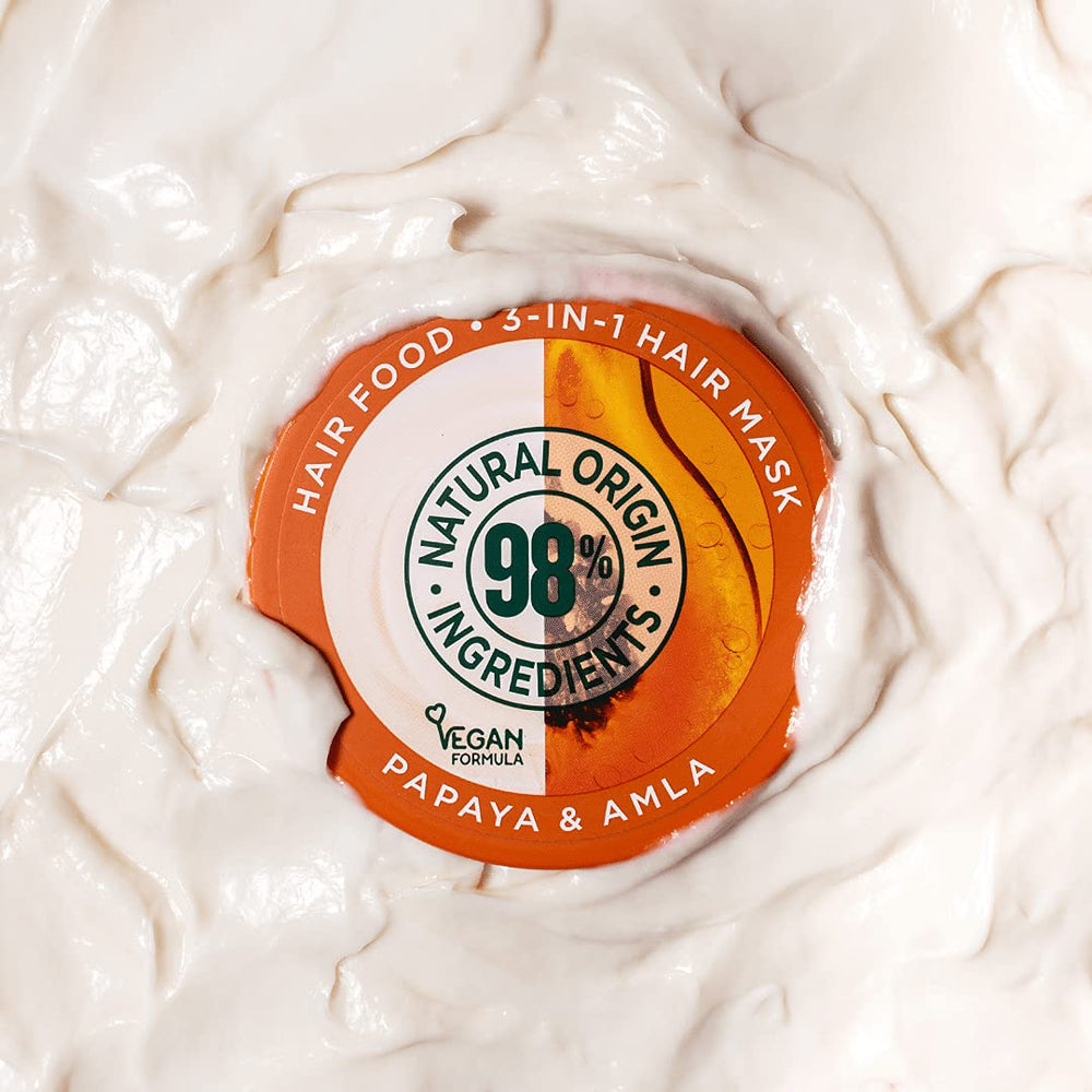 Garnier Hair Food Papaya 3-in-1 mask applied to damp hair for nourishment.