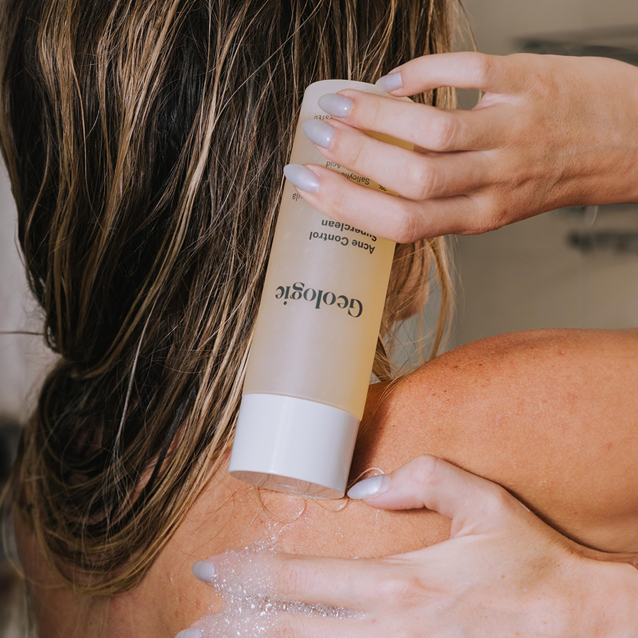Geologie Acne Control Body Wash lather closeup highlights 2% salicylic acid exfoliation.