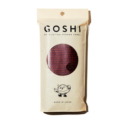GOSHI Exfoliating Towel brick red close-up shows durable rip-resistant weave for gentle exfoliation.