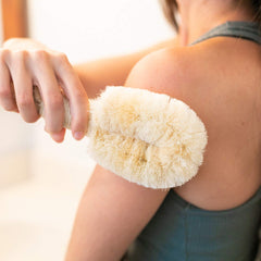 GranNaturals sisal brush resting on bathroom shelf for easy self care.