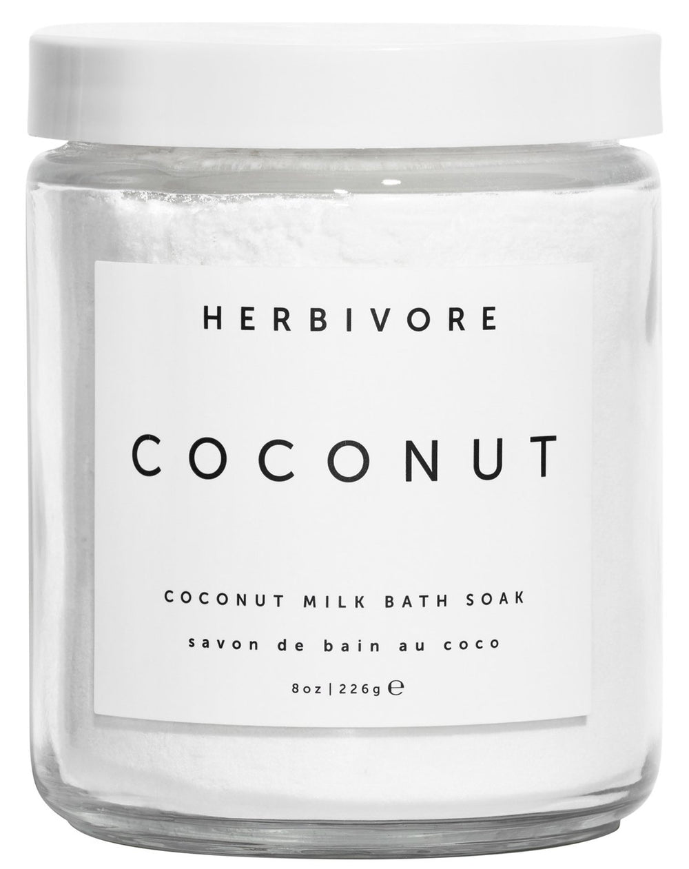 HERBIVORE Coconut Milk Bath Soak being poured into warm water for hydration.