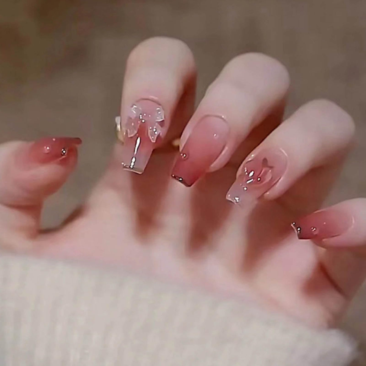 Uñas Hkanlre rosas con diseño mariposa, ideal para un look femenino y elegante.