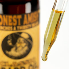 Honest Amish Classic Beard Oil 2oz pour showing easy application for grooming.