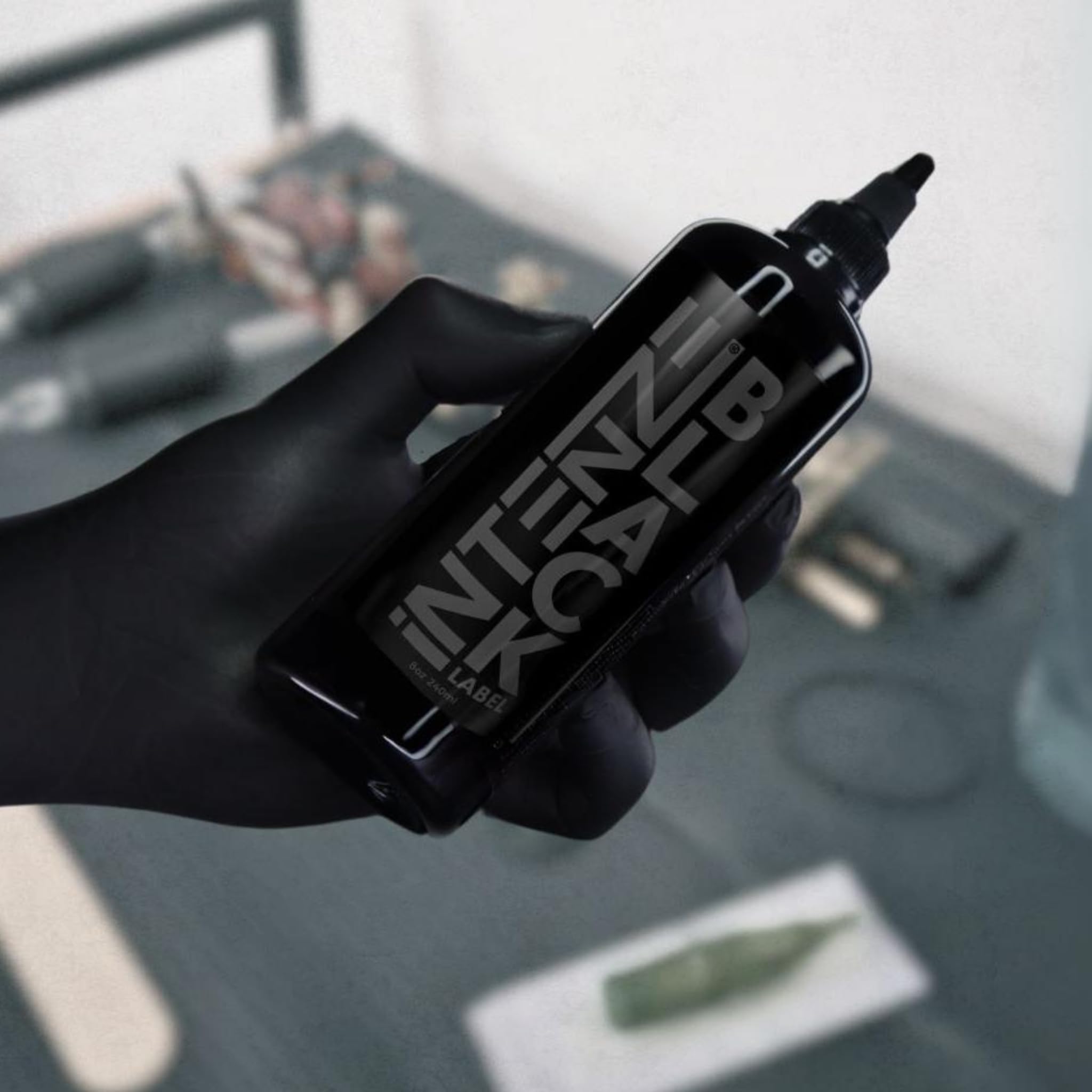 Intenze Black Label ink bottle on studio desk – trusted choice in professional tattoo rooms.