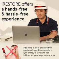 iRestore Essential user looking in mirror to track visible hair growth progress.