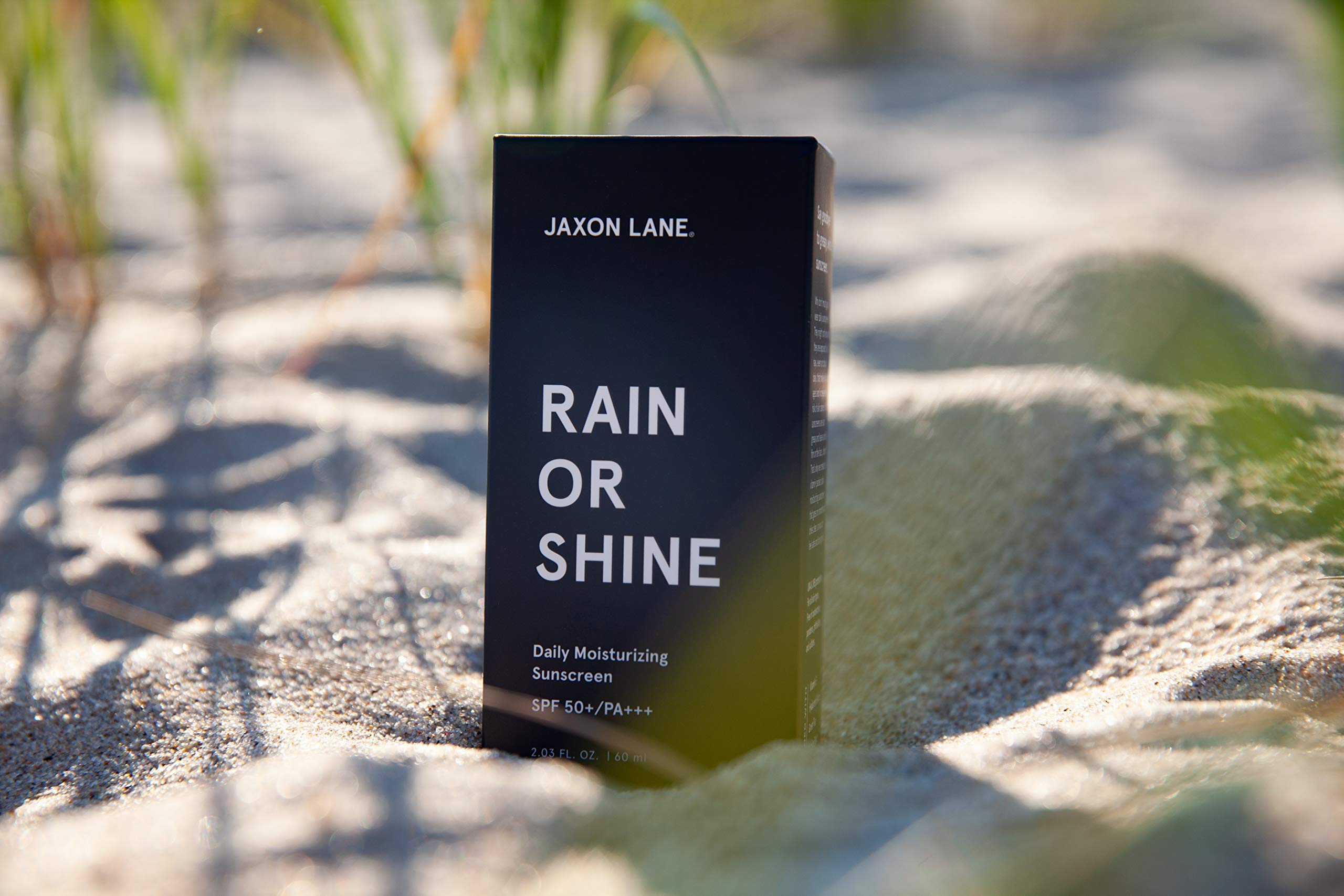 JAXON LANE Rain or Shine travel-size bottle beside passport for portability.