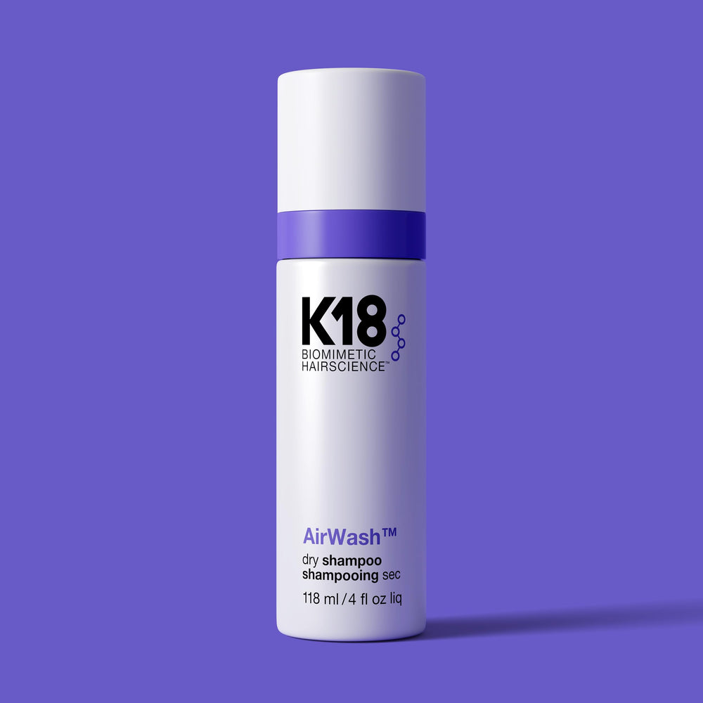 K18 AirWash Dry Shampoo application on hands for quick odor and oil management.