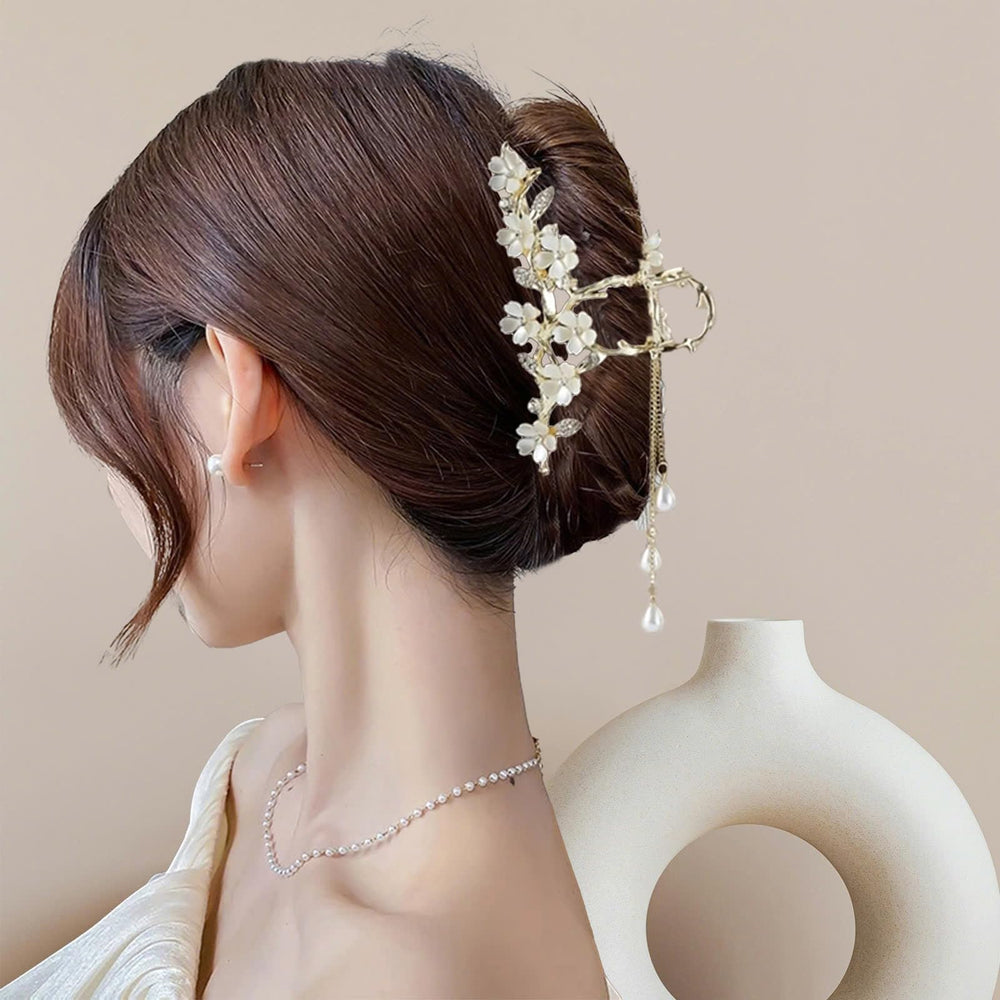 KEMMINTVN gold lily-of-the-valley clip highlights crystal accents for subtle evening glam.