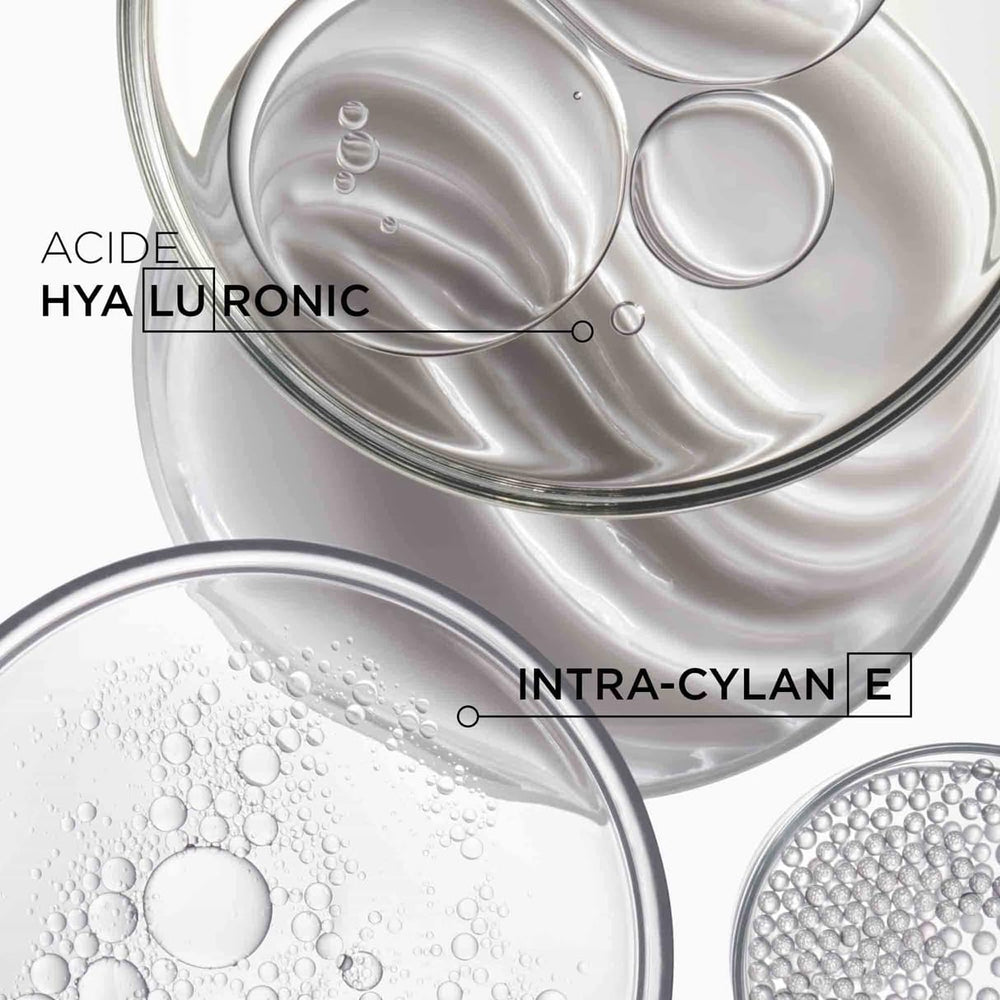 KÉRASTASE Densifique bottle packaging highlights hyaluronic acid benefits.