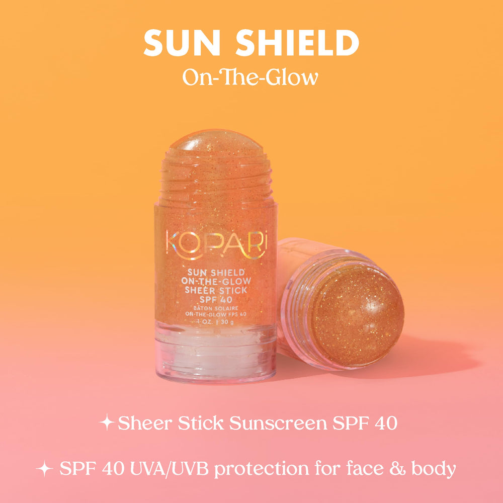 Kopari Sun Shield stick beside beach towel showing outdoor use