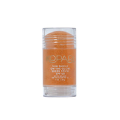 Kopari Sun Shield On-The-Glow stick in hand for on-the-go protection