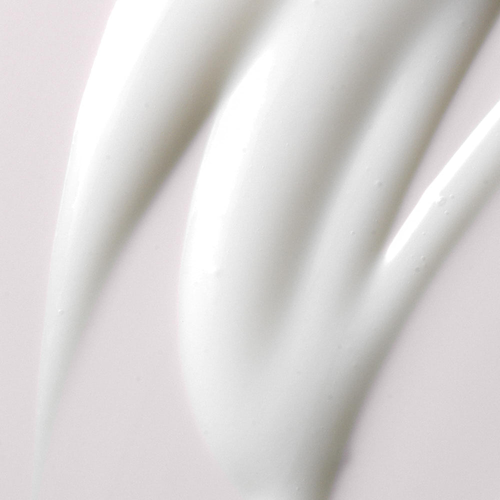 Kristin Ess Ultra Hydrating Curl Leave-In Cream on model's curls showcases added shine after use.