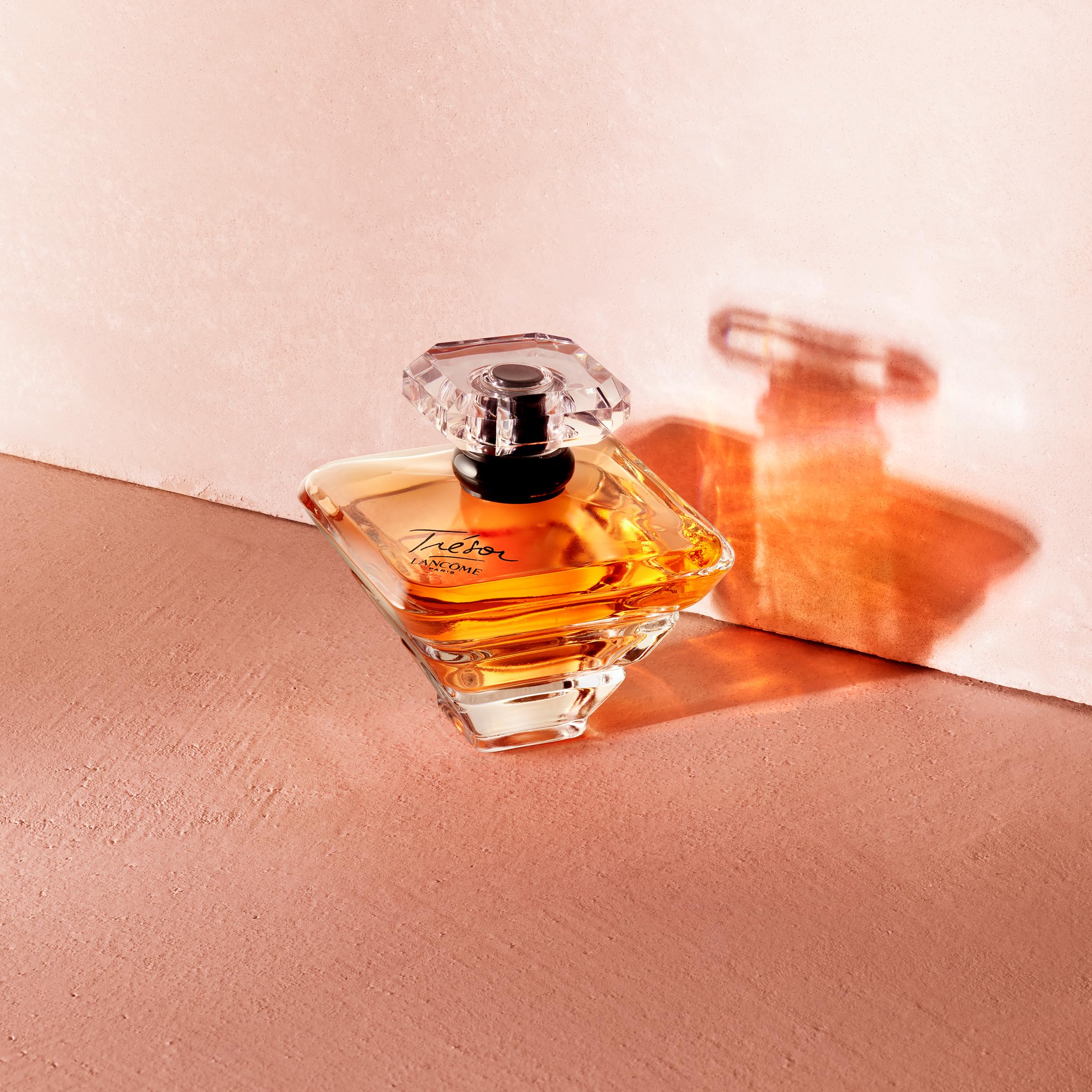 Lancôme Trésor frasco dorado con tapón de diamante, lujo visible.