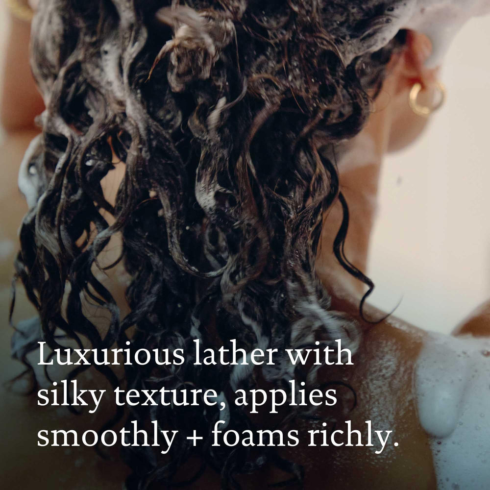 Living Proof Perfect Hair Day Shampoo close-up showing natural shine on strands.