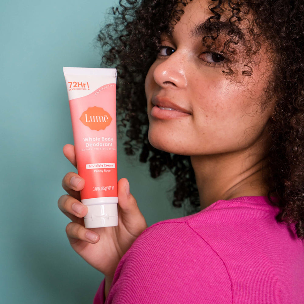 Lume Peony Rose applying underarm to prevent odor with gentle rub.