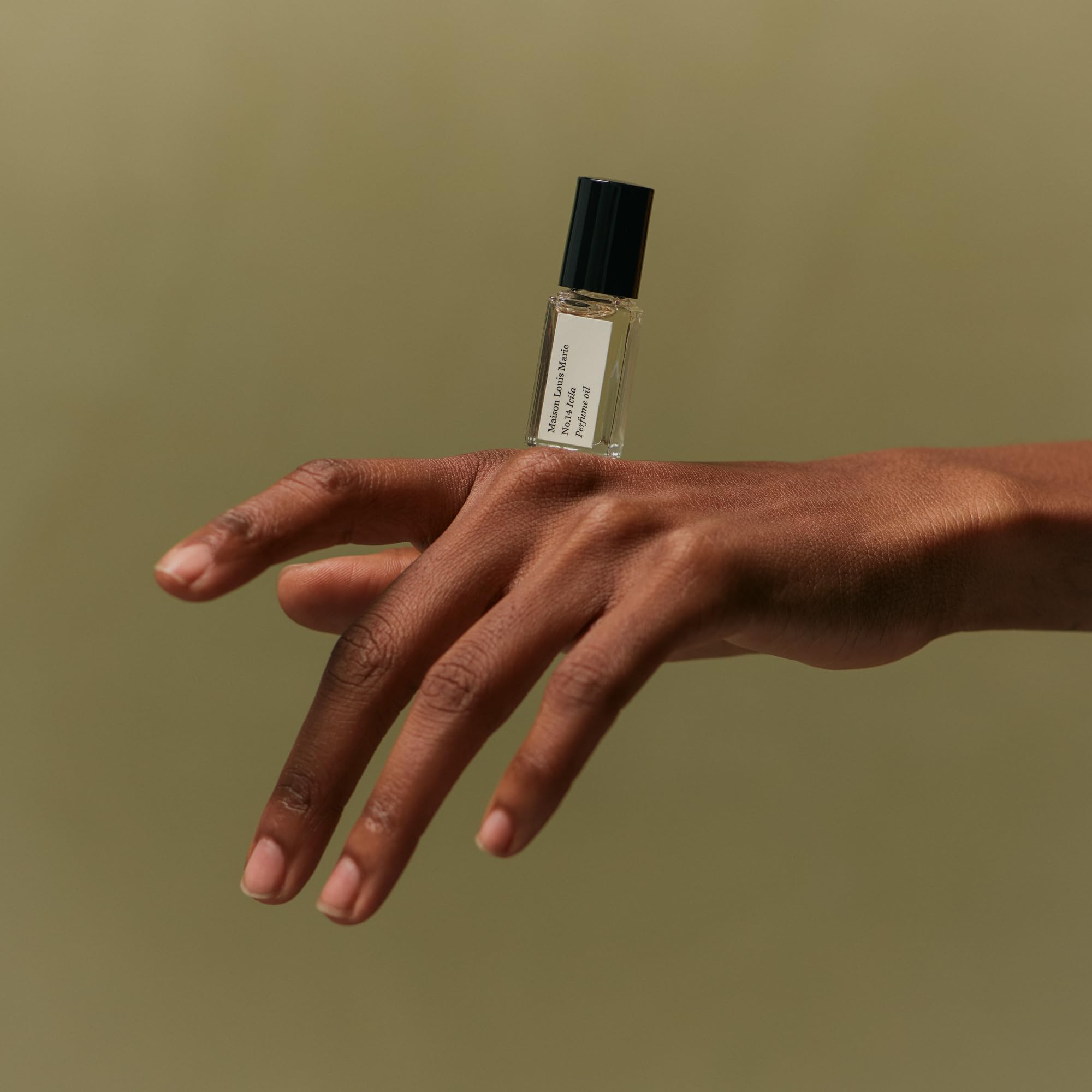 Applying Icila roll-on to pulse points for intimate, long-lasting scent performance.