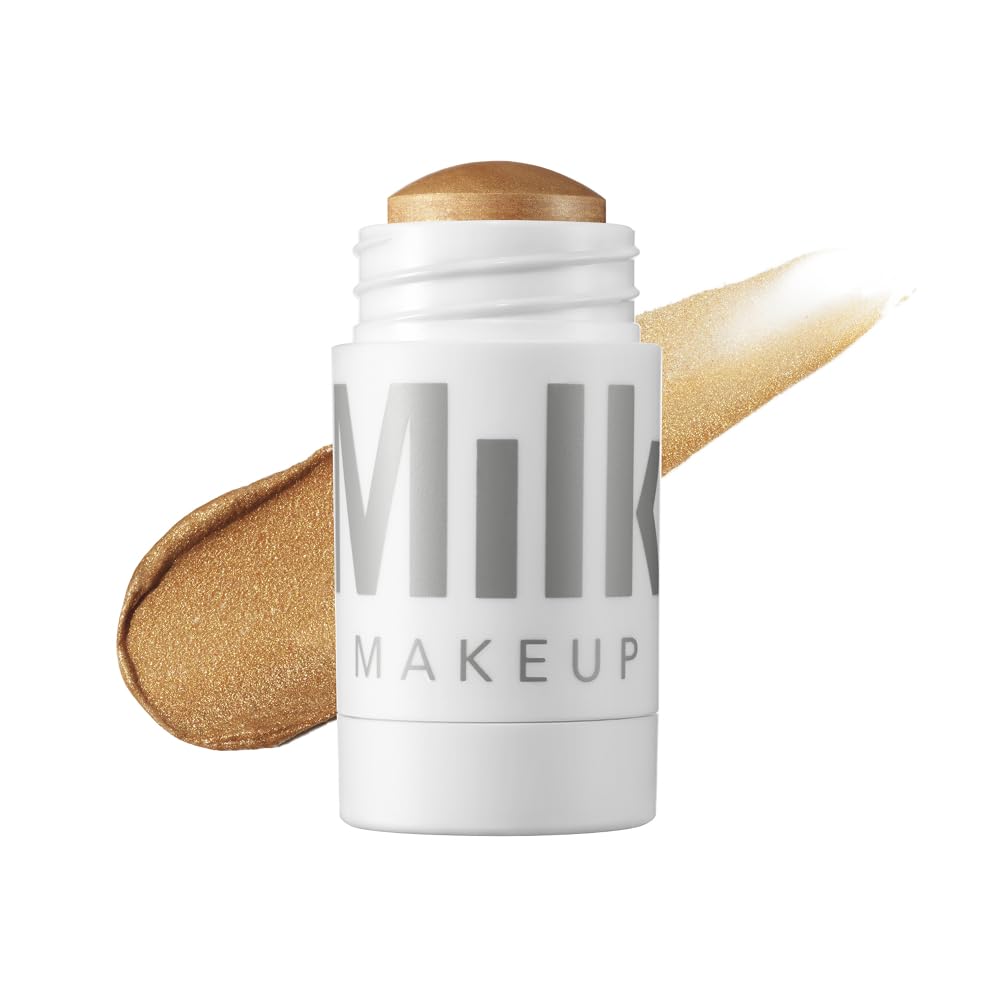 Milk Makeup Highlighter Strobe Gold on face for a dewy glow.