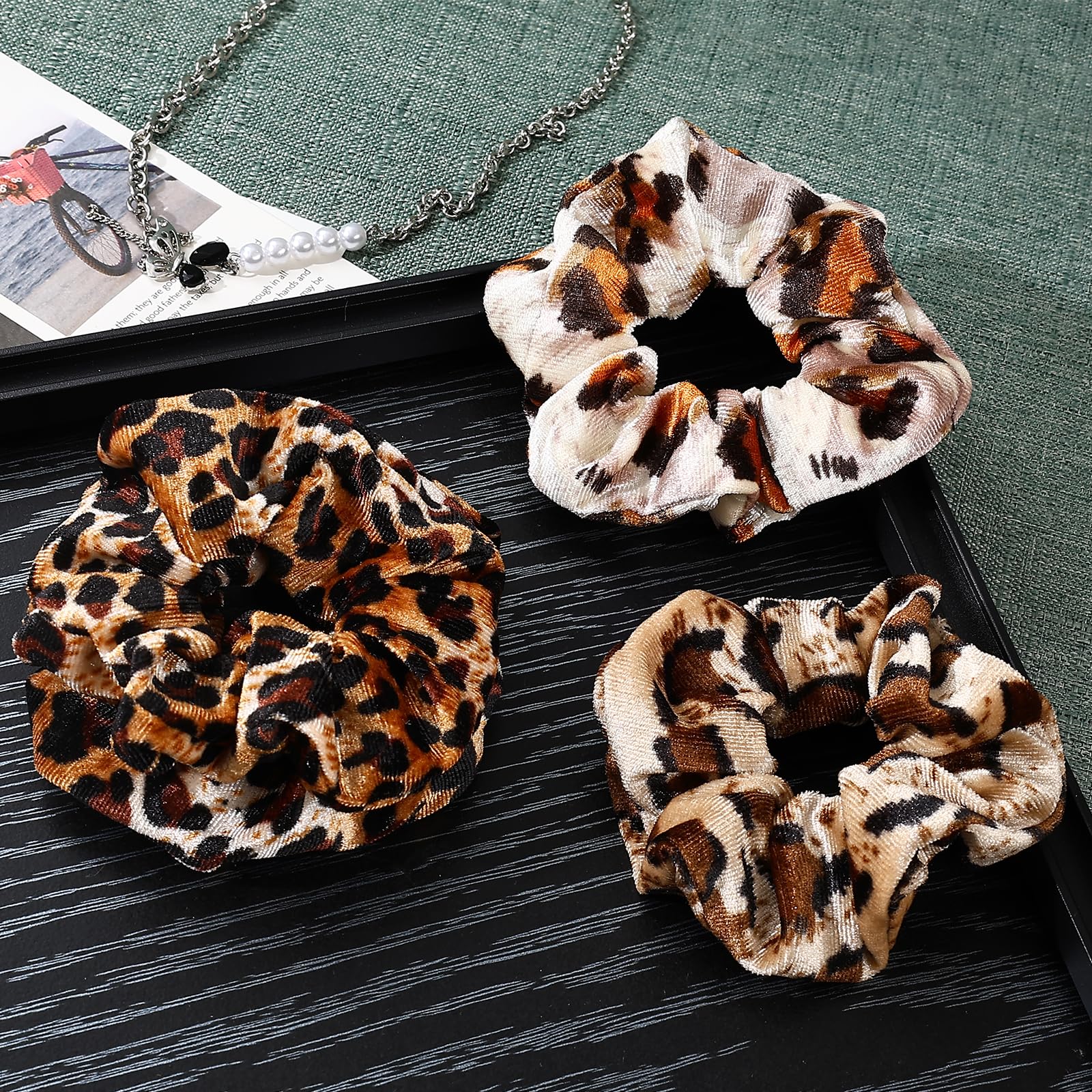 Mirlern leopard velvet scrunchies pair on hand, versatile fashion accessory for many looks.