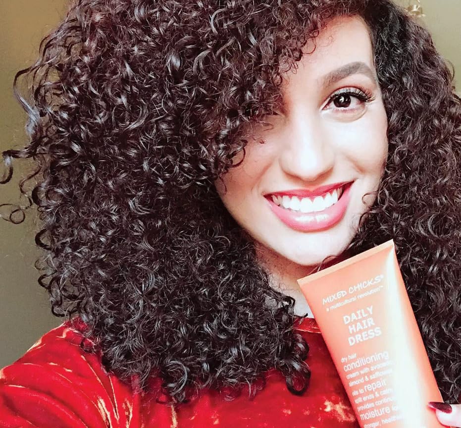 Mixed Chicks Daily Hair Dress bottle beside a comb for daily styling and moisture.